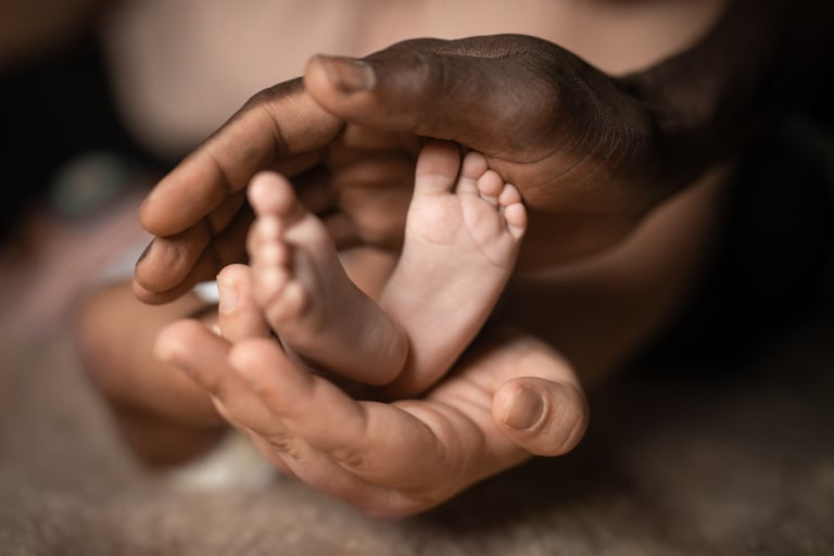 Hands holding feet of a newborn baby