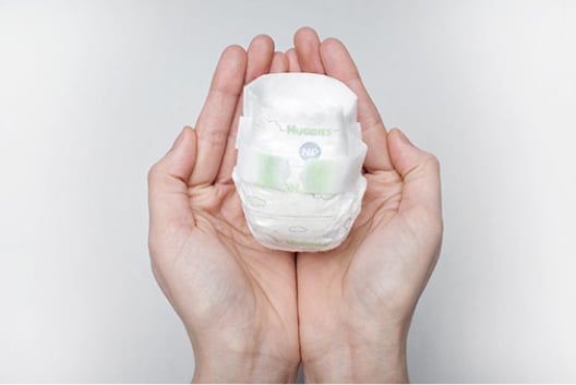 Huggies Little Snugglers Nano Preemie Diapers in hands showing comforting graphics to help support bonding with baby