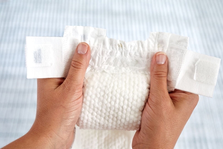 Hands holding breathable disposable diapers